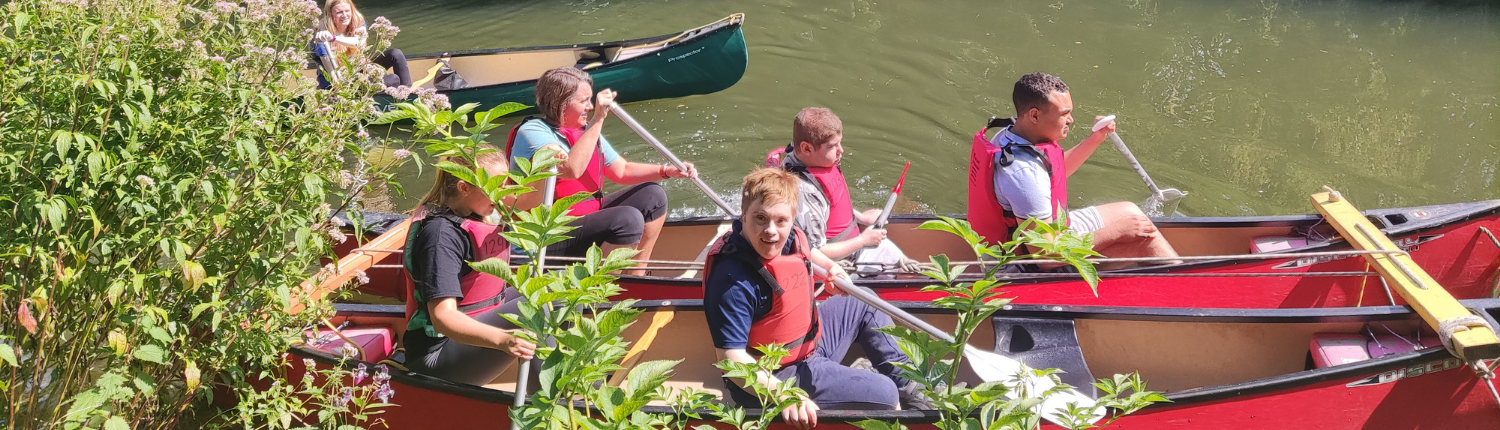 Accuro staff and members smiling in a red kayak