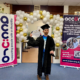 STRIDE Member in a Graduation Cap and Gown holding his certificate