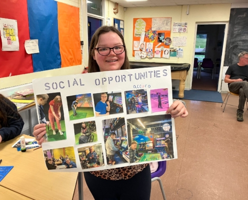 Accuro member holding a poster displaying photos of social opportunities.