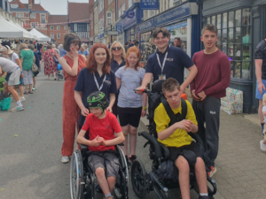 Six people in Saffron Walden, including Accuro staff, with two young service users in wheelchairs.