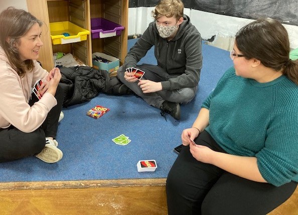 Tia, as a member of Cool Connections, playing cards with another member, and staff member.